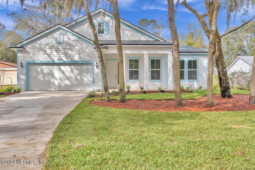 a front view of a house with a yard and plants