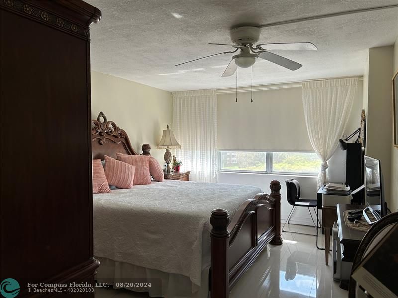 a bedroom with a bed and a flat tv screen on the dresser