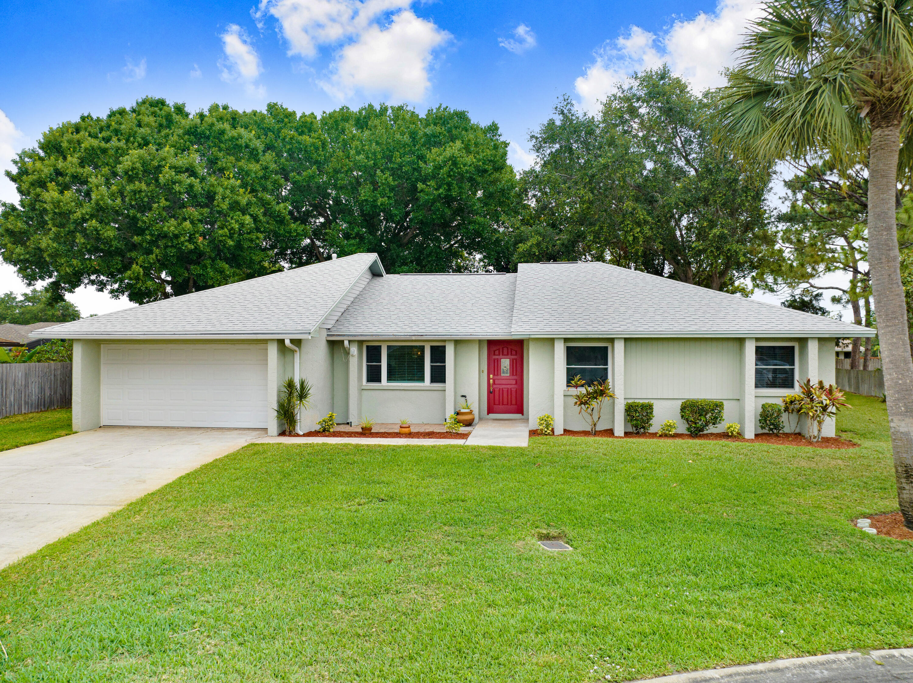 a front view of a house with a yard and trees