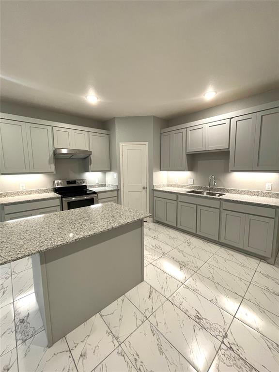 a kitchen with stainless steel appliances granite countertop a sink and a stove