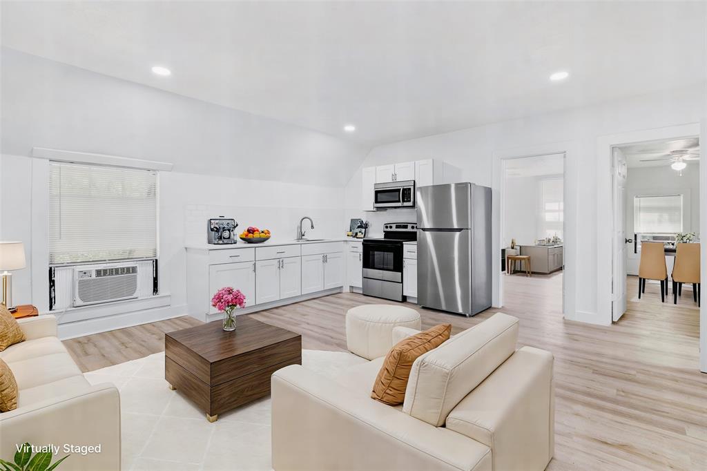 a living room with furniture and kitchen view