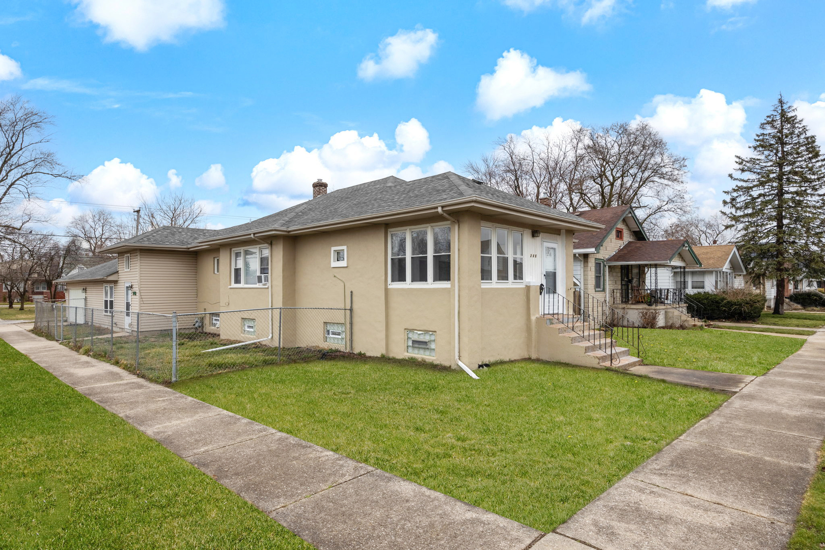 a front view of a house with a yard and trees