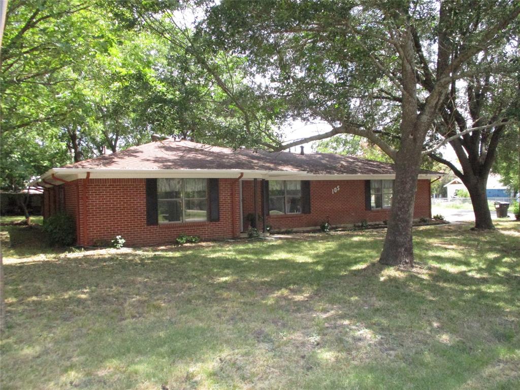 a view of a house with a yard and large tree