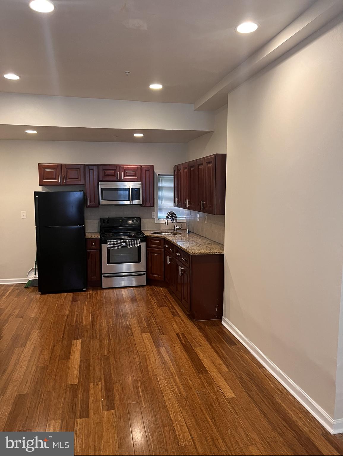 a kitchen with stainless steel appliances a refrigerator and a stove top oven