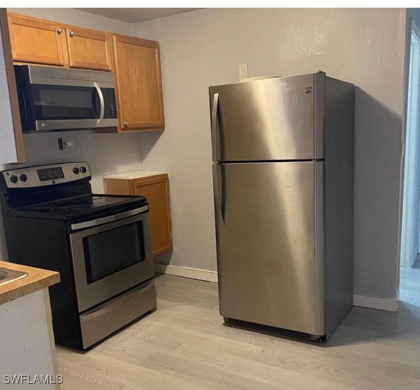 a kitchen with a refrigerator stove and microwave