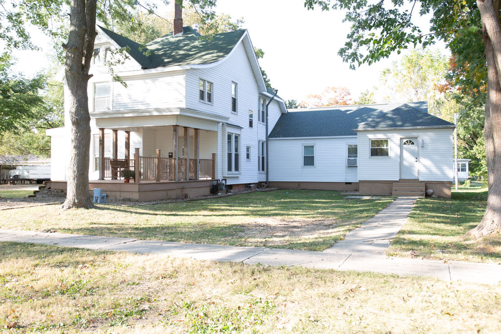 a view of a house with a big yard and large trees