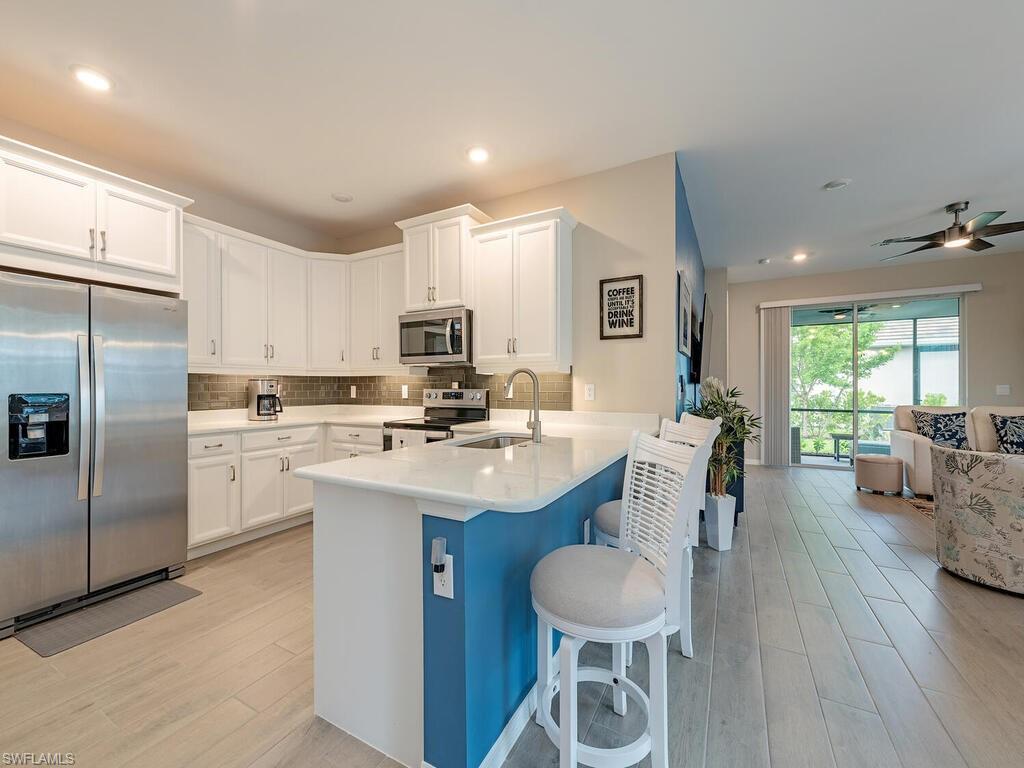 a kitchen with a sink stainless steel appliances and white cabinets