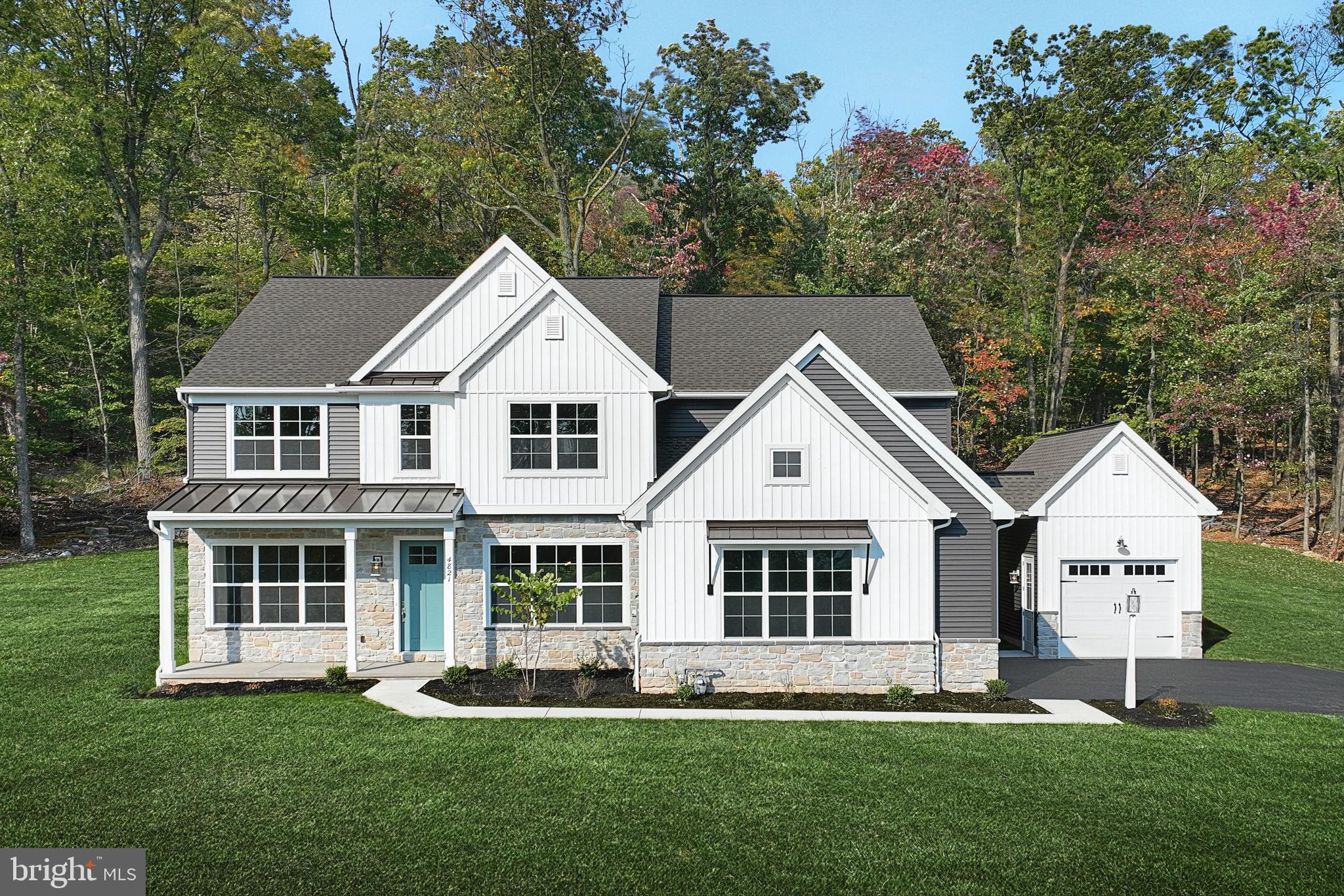 a front view of a house with a yard and trees