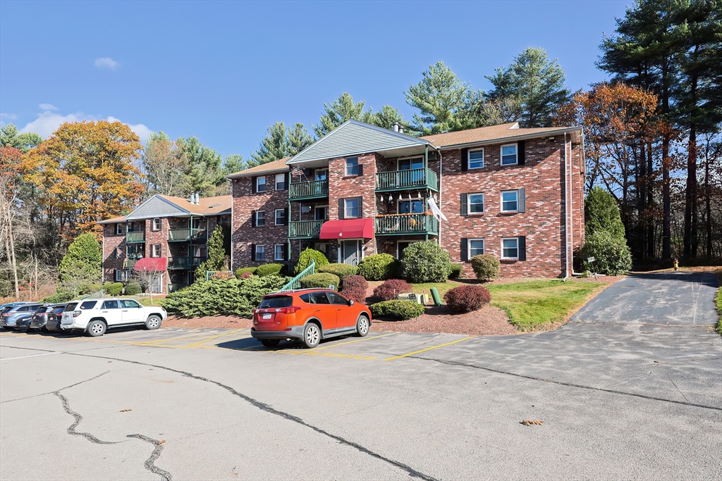 a front view of a building with parked cars