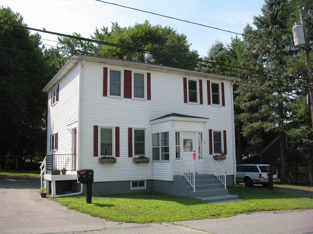 a front view of a house with a yard and sitting area