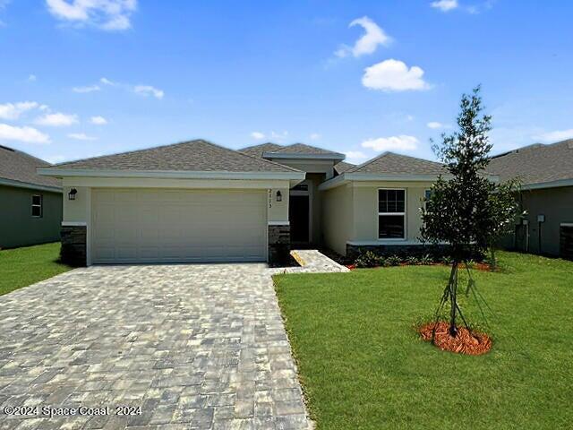 a front view of a house with a yard and garage