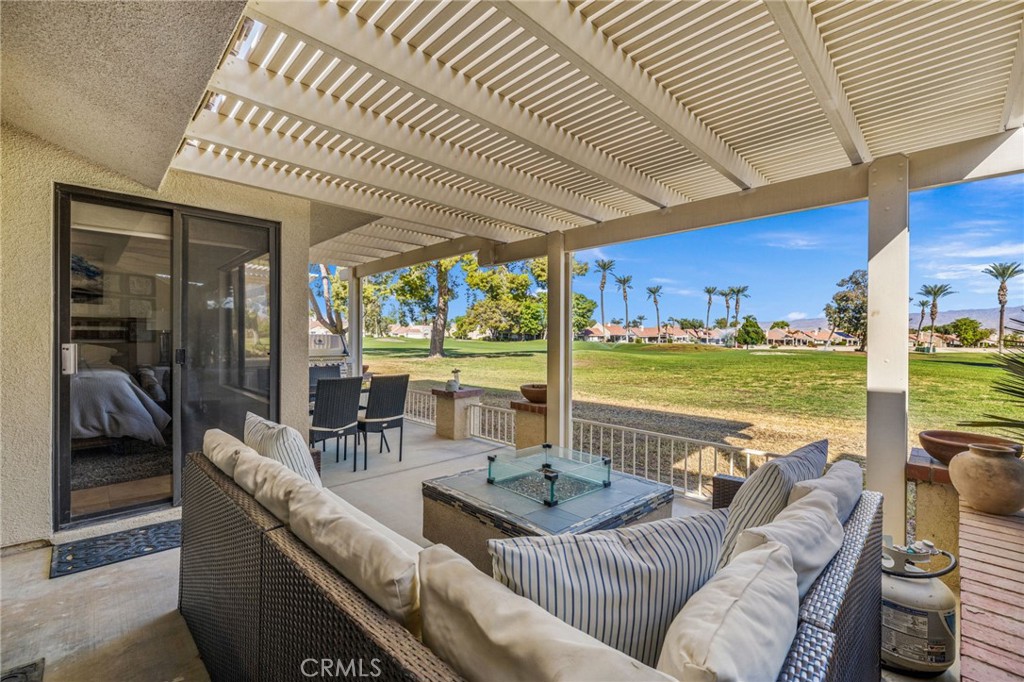 a living room with furniture floor to ceiling window and an outdoor kitchen