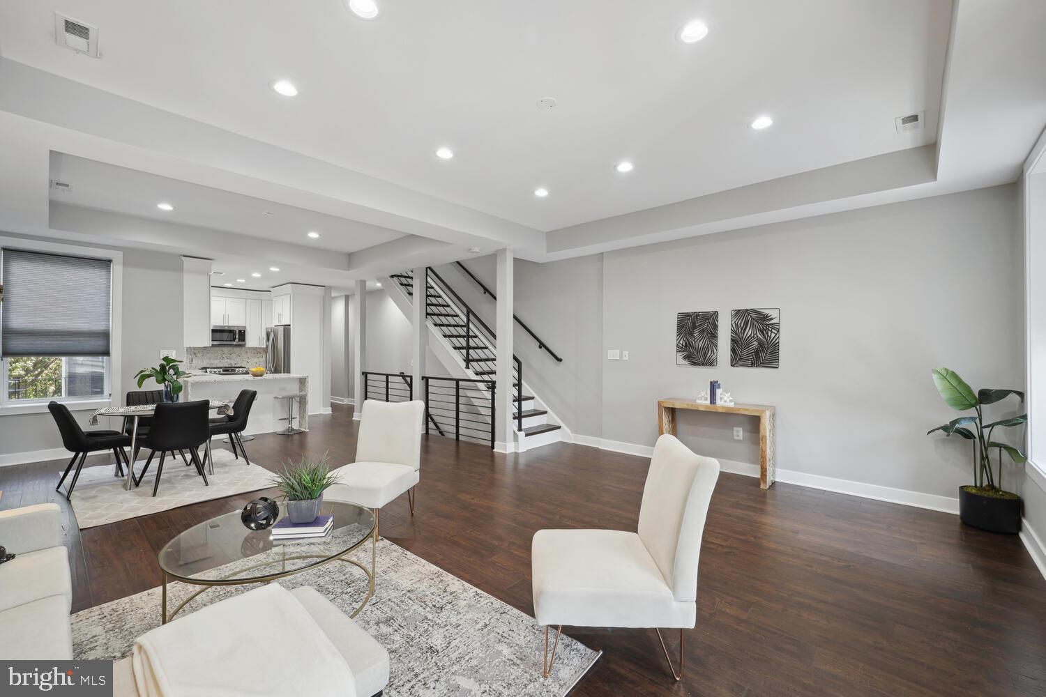 a living room with furniture a wooden floor and a potted plant