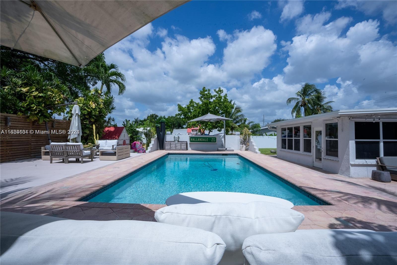 a view of a house with swimming pool and sitting area