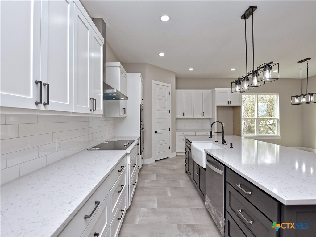 a large kitchen with stainless steel appliances granite countertop a sink a stove and a refrigerator