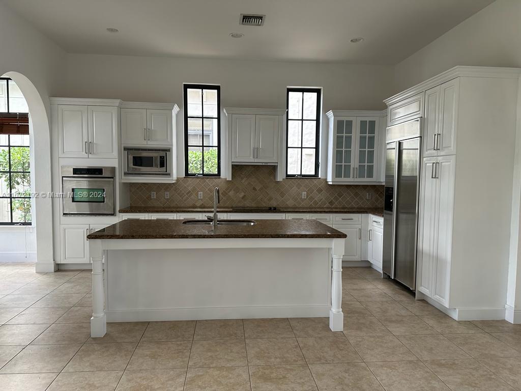 a kitchen with stainless steel appliances granite countertop a stove a sink and a refrigerator