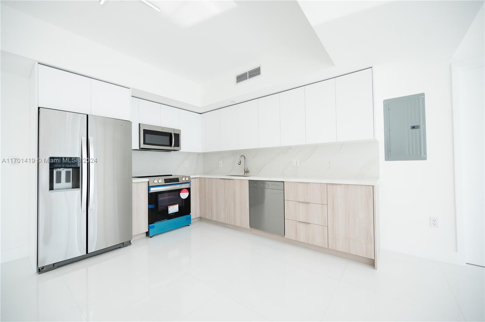 a kitchen with stainless steel appliances a refrigerator sink and white cabinets