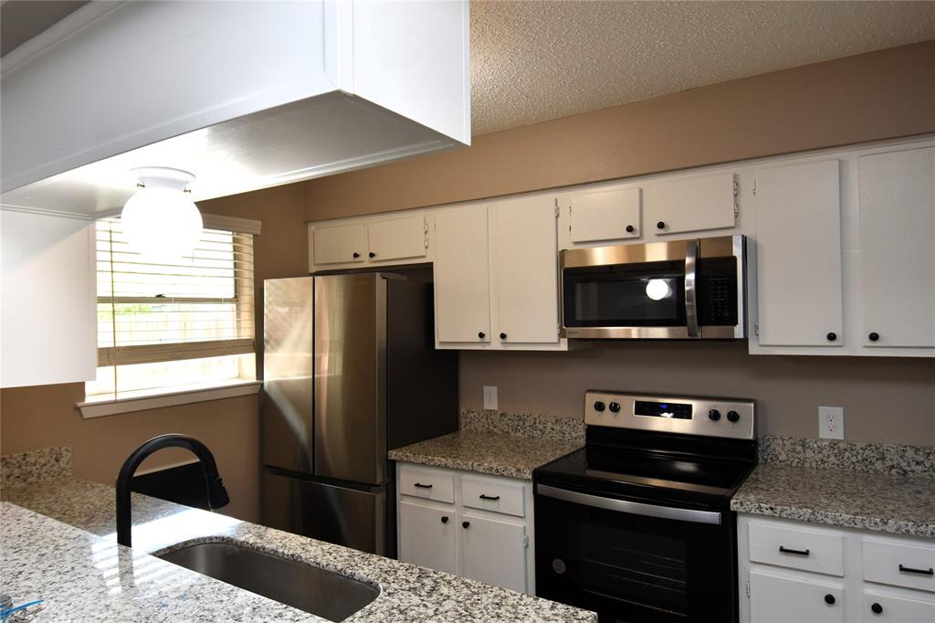 a kitchen with stainless steel appliances granite countertop a refrigerator sink and stove