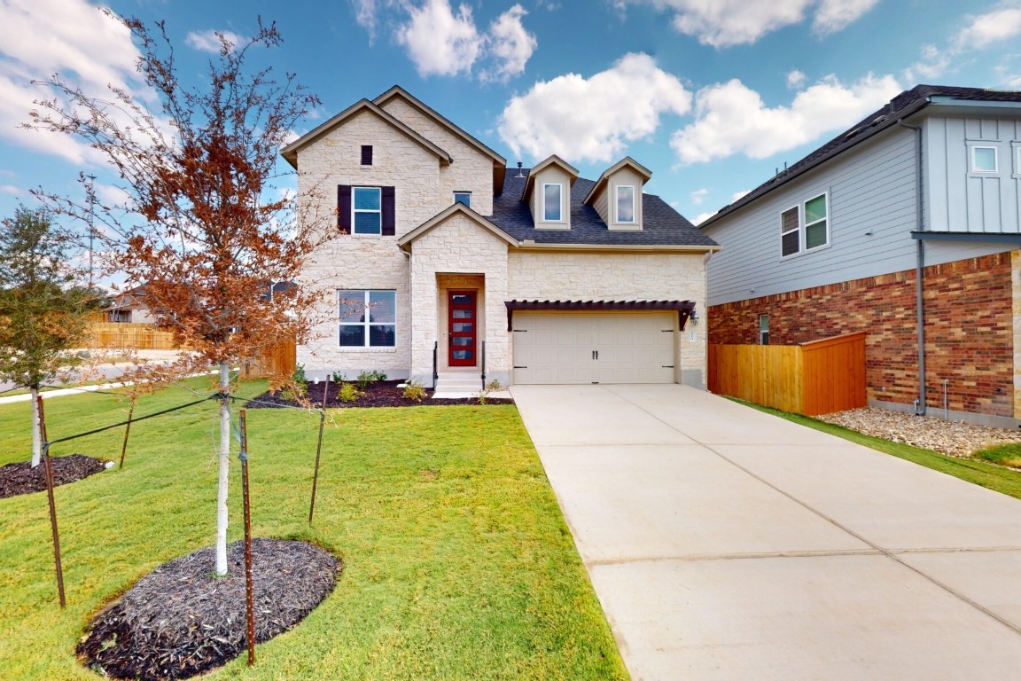 a front view of a house with a yard and garage