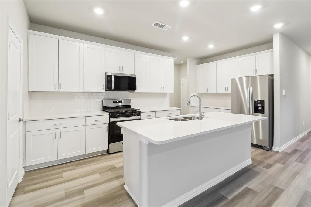 a kitchen with a sink stove and refrigerator