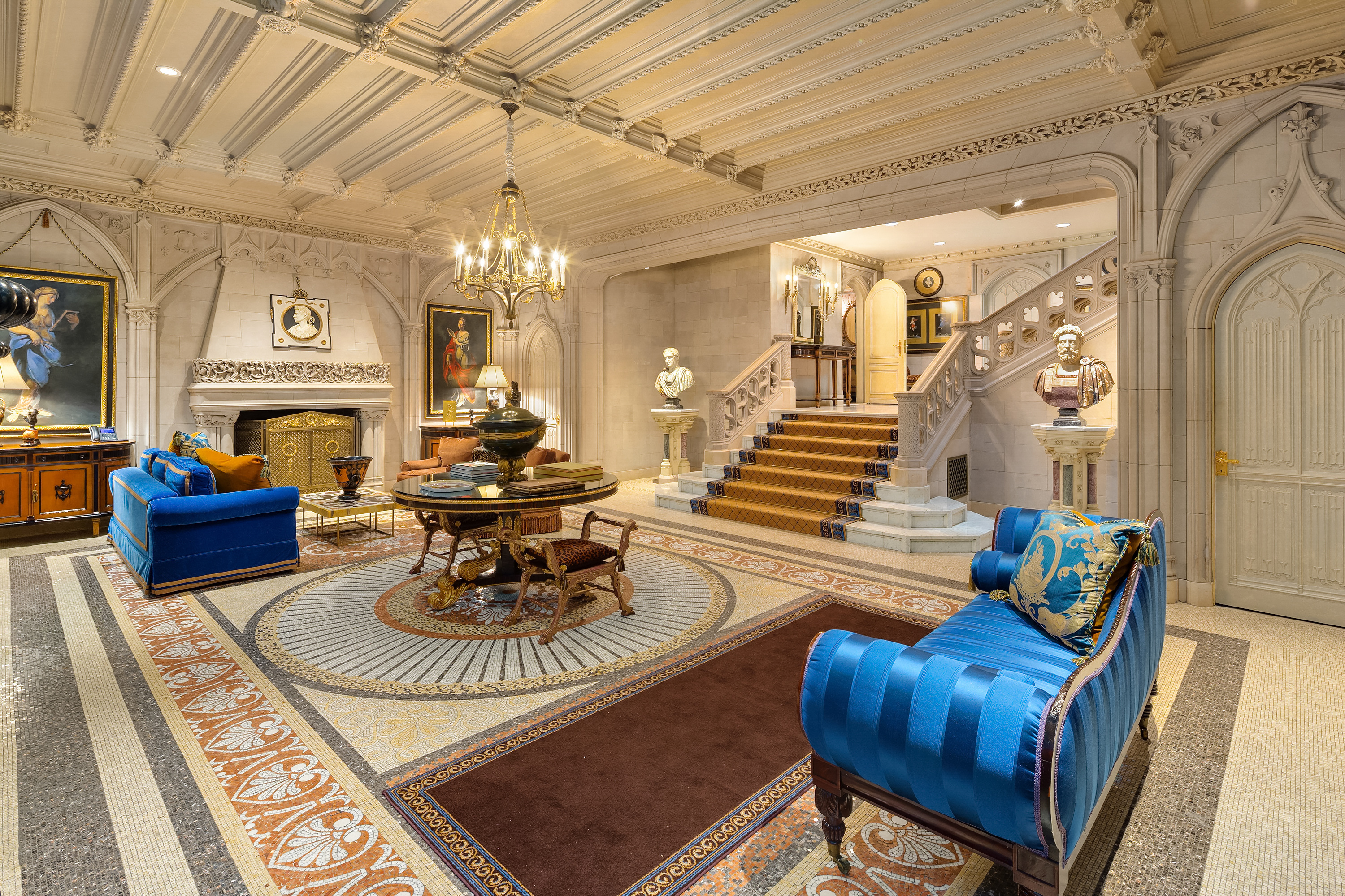 a living room with furniture a fireplace and a chandelier