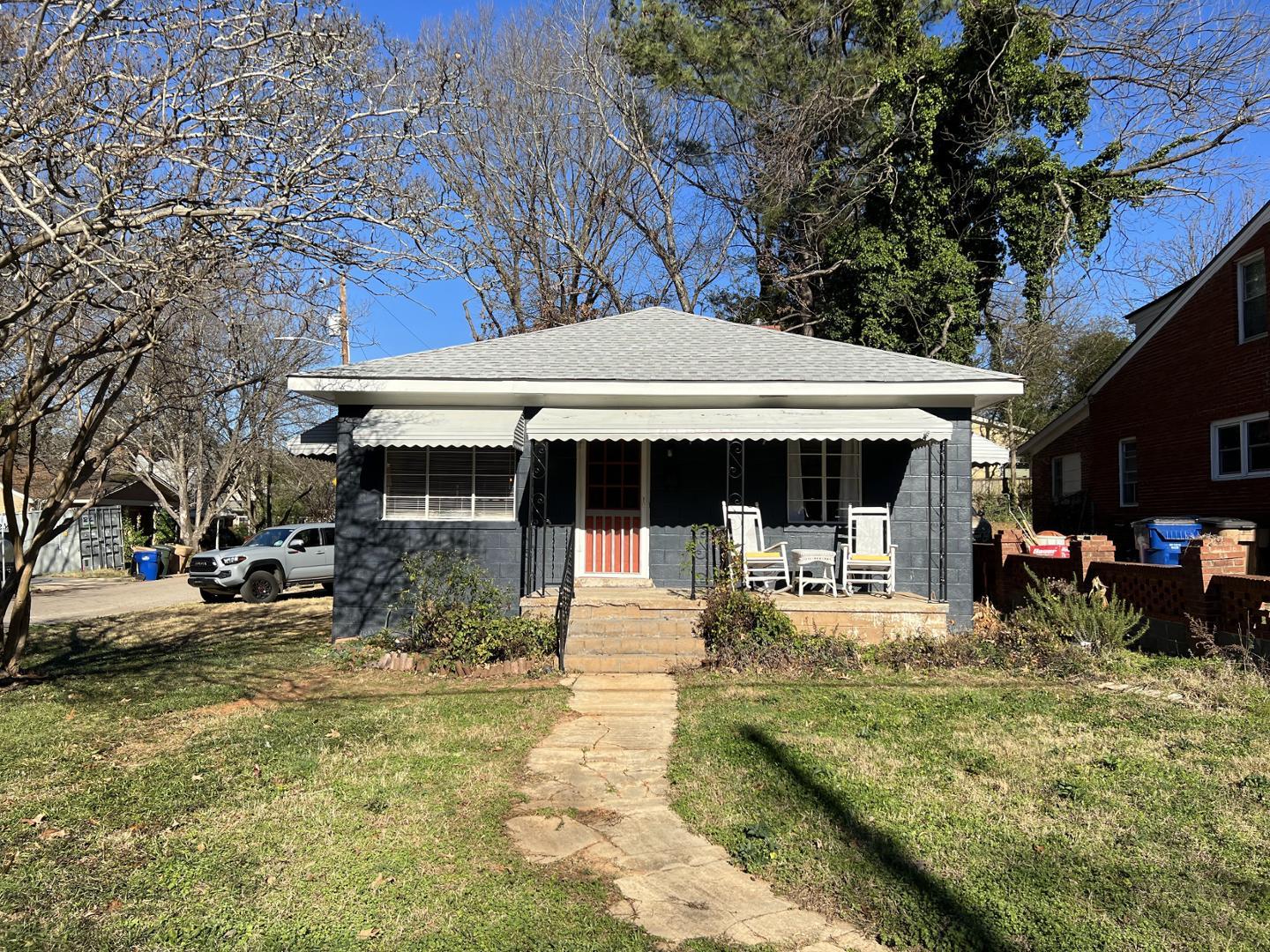 a front view of a house with garden and sitting area