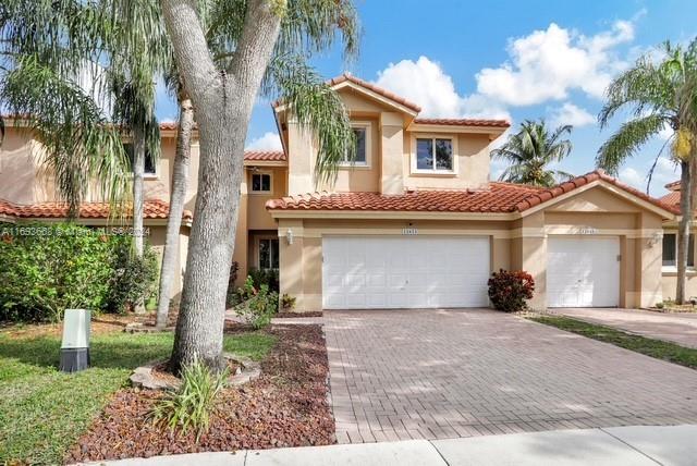 a front view of a house with a yard and a garage