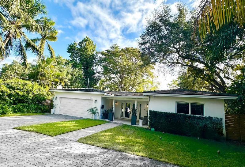 a front view of house with yard and trees