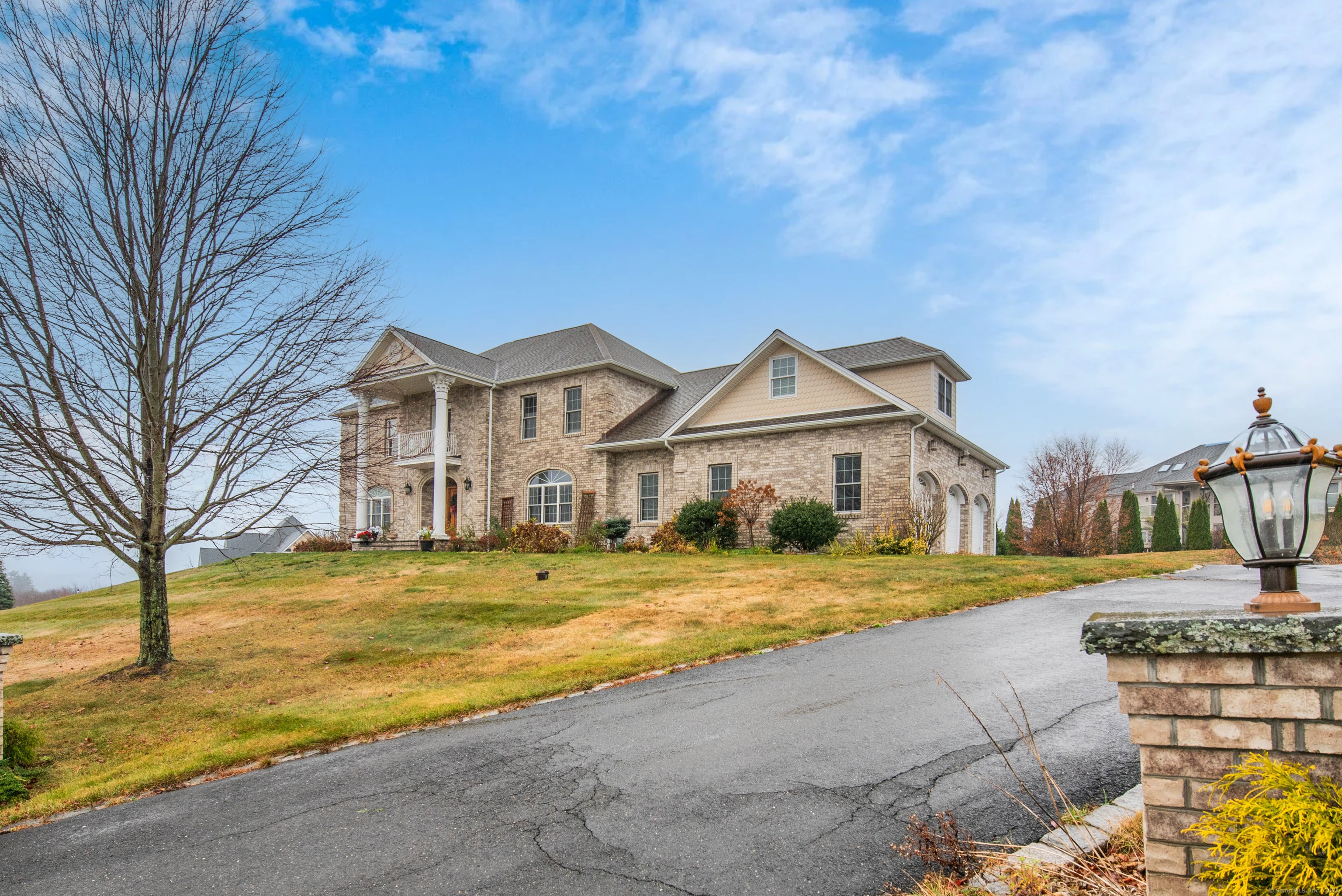 a view of a big house with a big yard and large trees