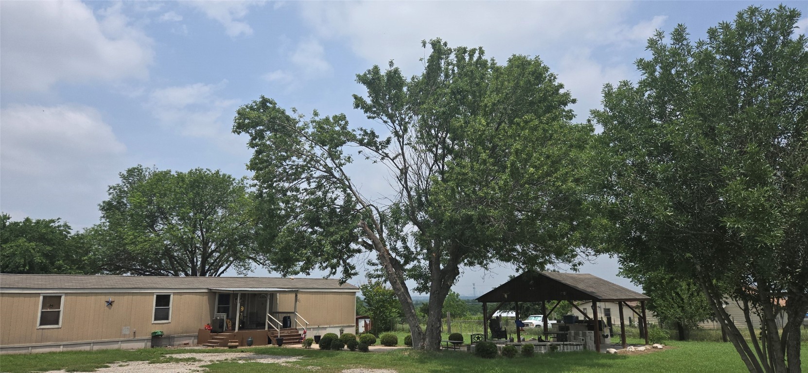 a front view of a house with garden and trees