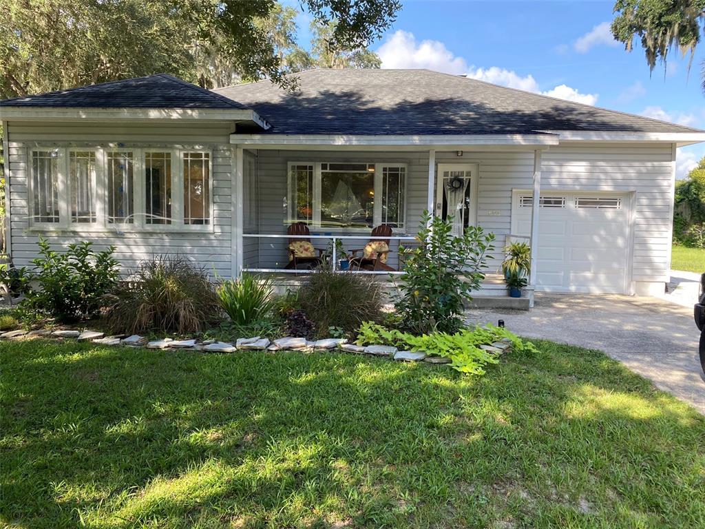 a front view of a house with a yard and potted plants