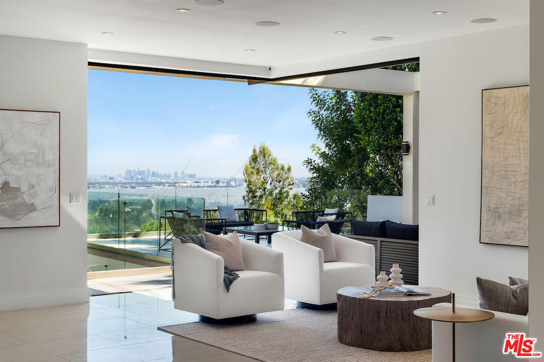 a living room with patio furniture and a floor to ceiling window