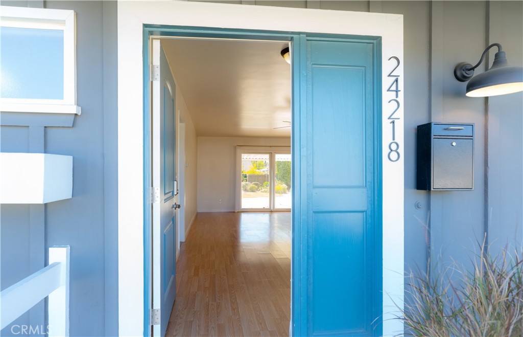 a view of a hallway with wooden floor and a bathroom