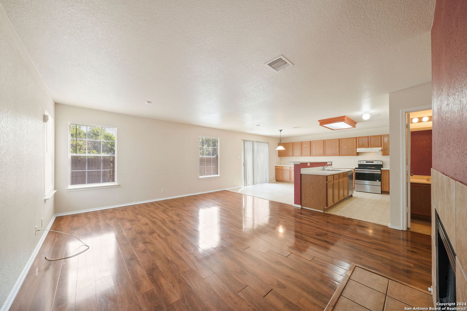 a view of a living room with stainless steel appliances wooden floor and view living room