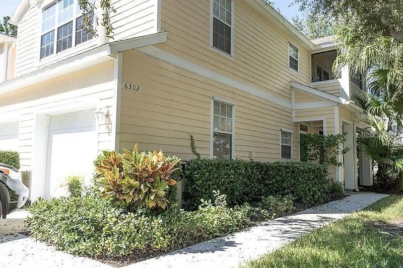 a view of a house with a yard and potted plants