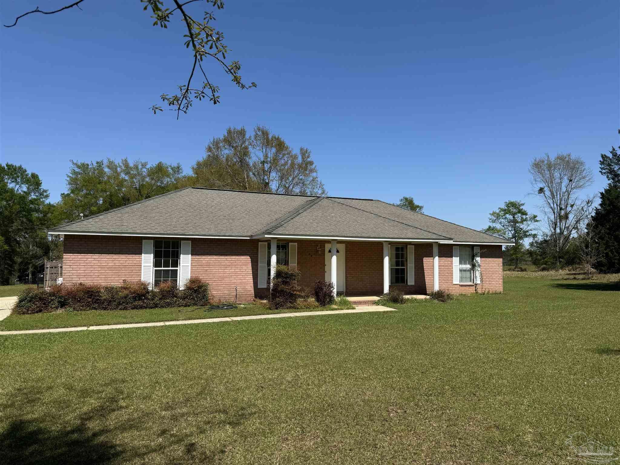 a front view of a house with a yard and trees