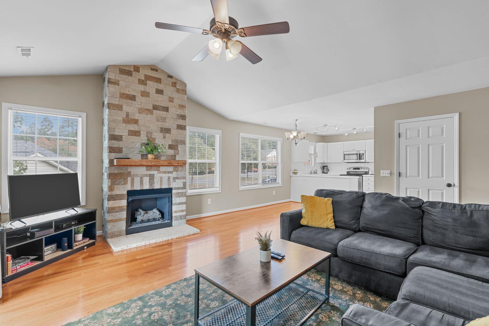 a living room with furniture a flat screen tv and a fireplace