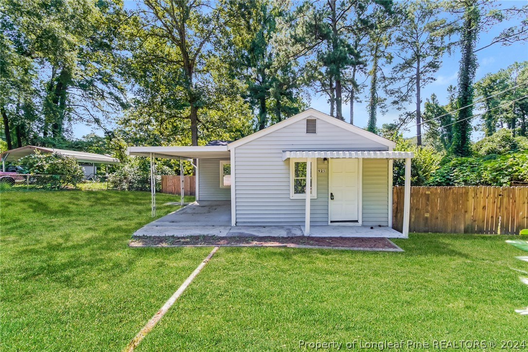 a view of house with backyard and trees