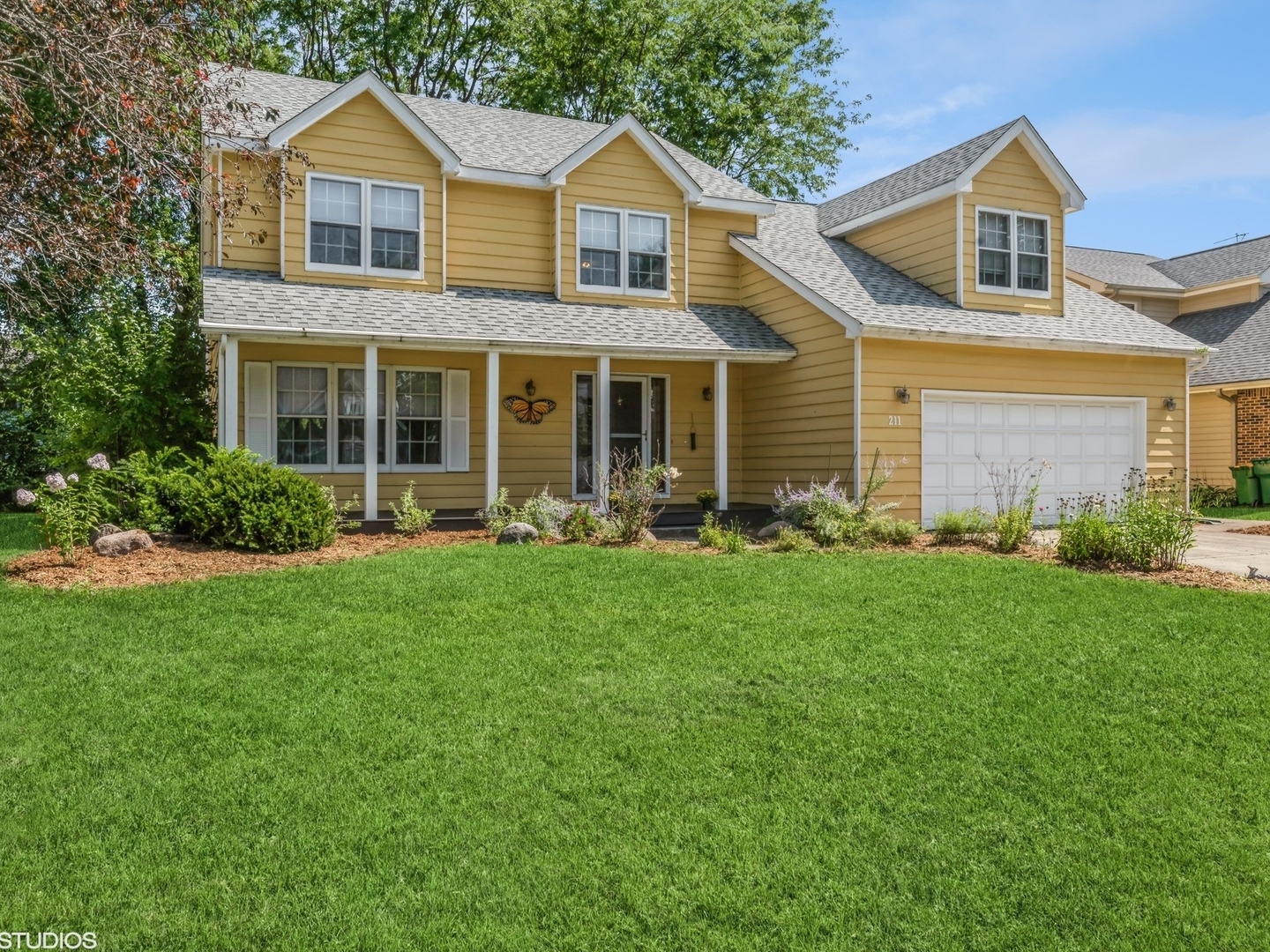 a front view of a house with a yard and green space