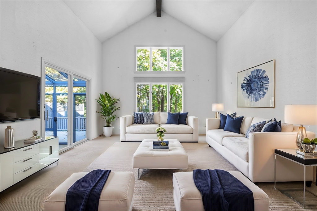 a living room with furniture a flat screen tv and a large window