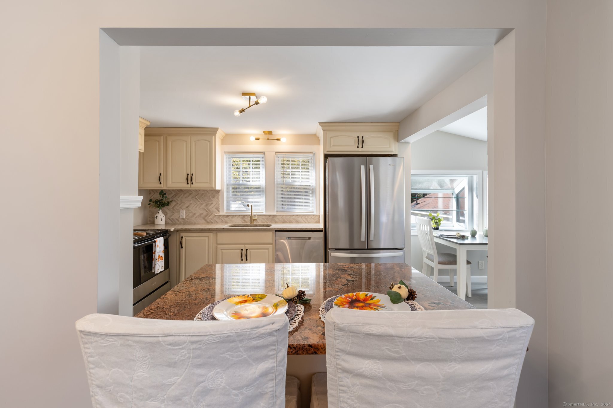 a kitchen with stainless steel appliances kitchen island granite countertop a sink and refrigerator