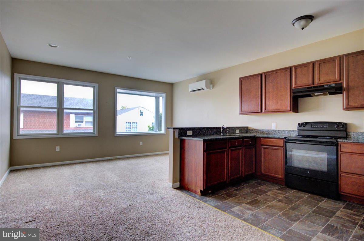 a kitchen with stainless steel appliances granite countertop a stove a sink and a refrigerator