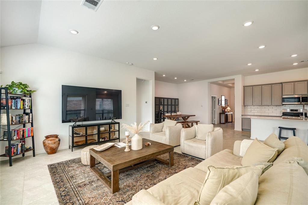 This stunning entryway features elegant tray ceilings and recessed lighting, creating a warm and inviting atmosphere as you step inside.