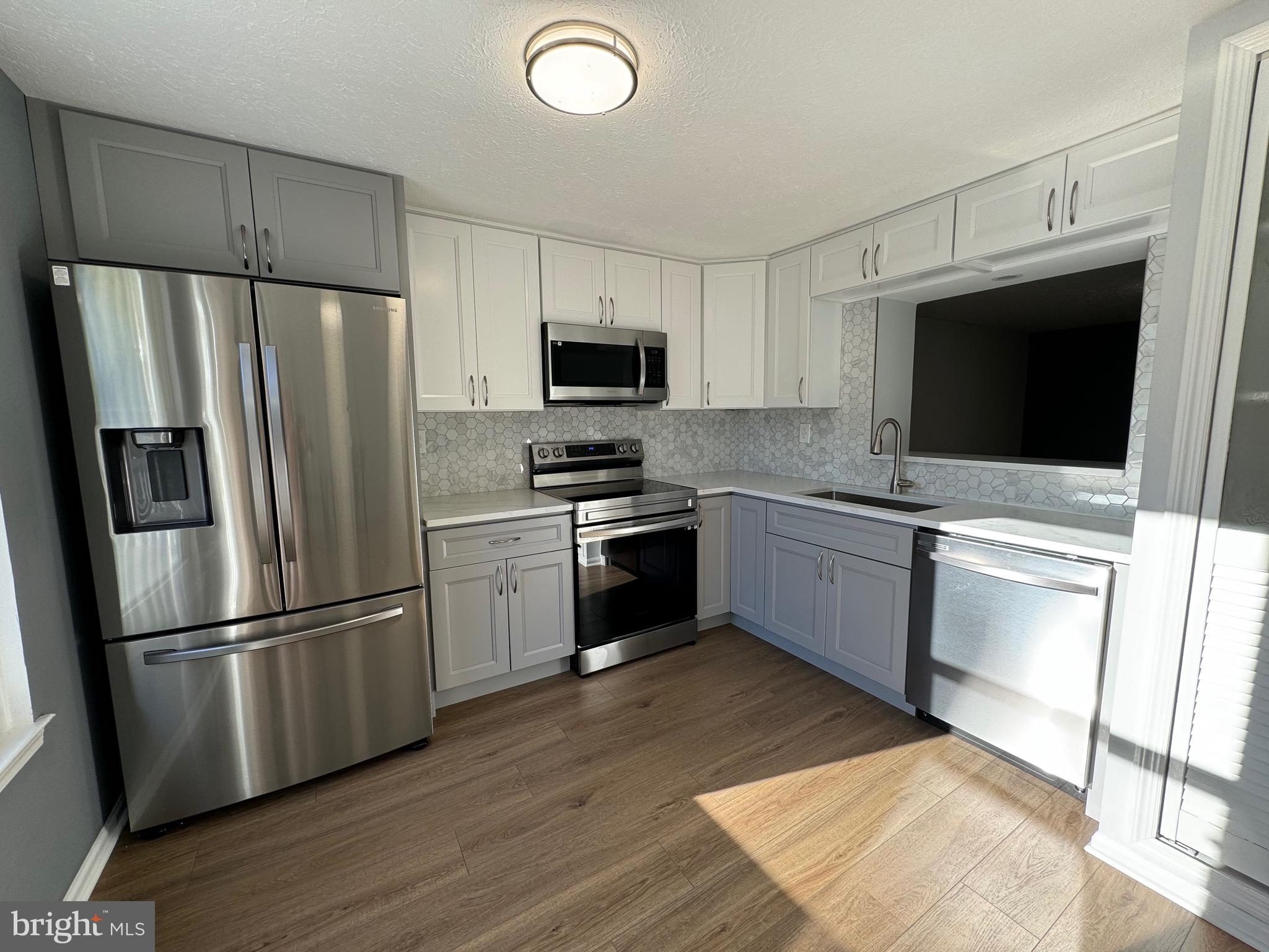 a kitchen with a refrigerator stove and microwave