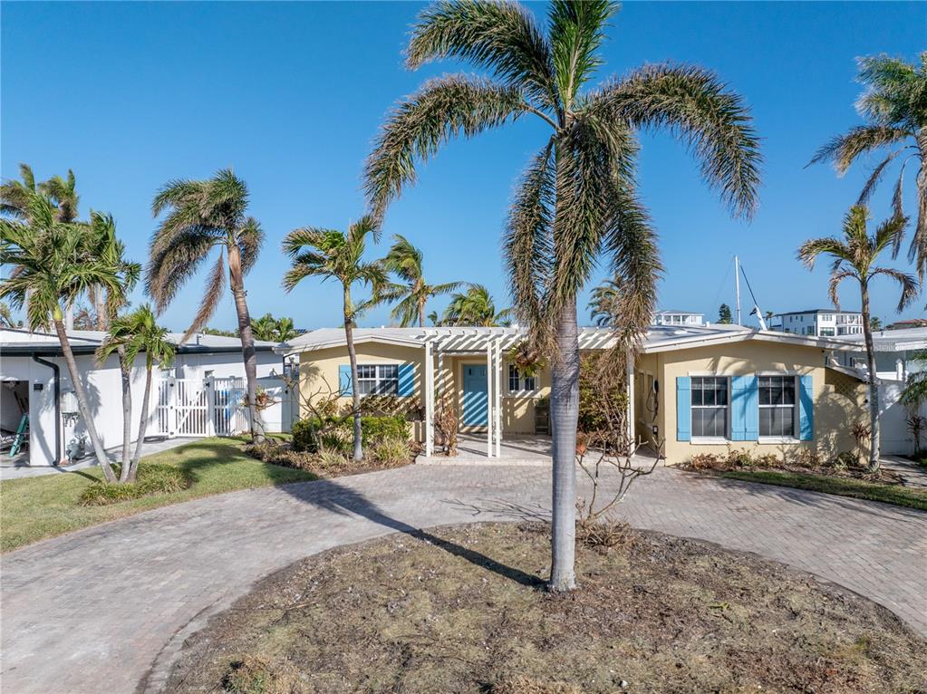 a view of a house with a yard and palm trees