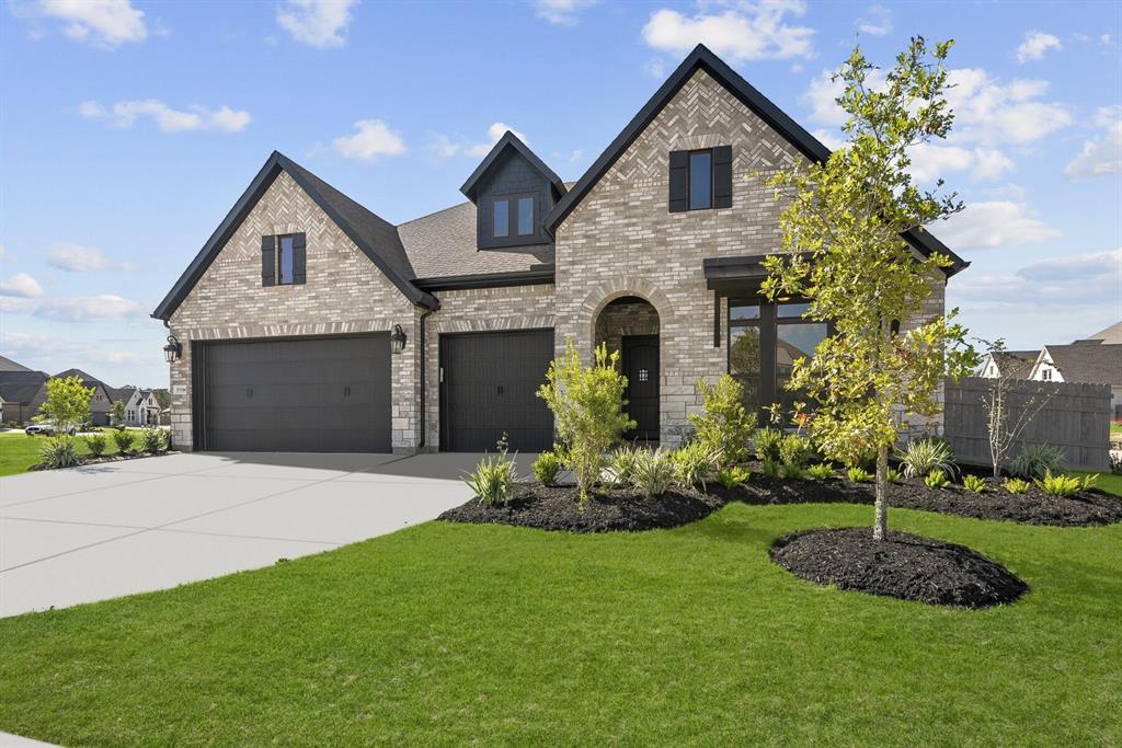 a front view of a house with a garden and garage