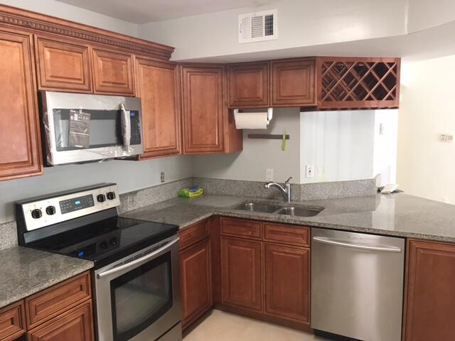 a kitchen with stainless steel appliances granite countertop a sink stove and microwave