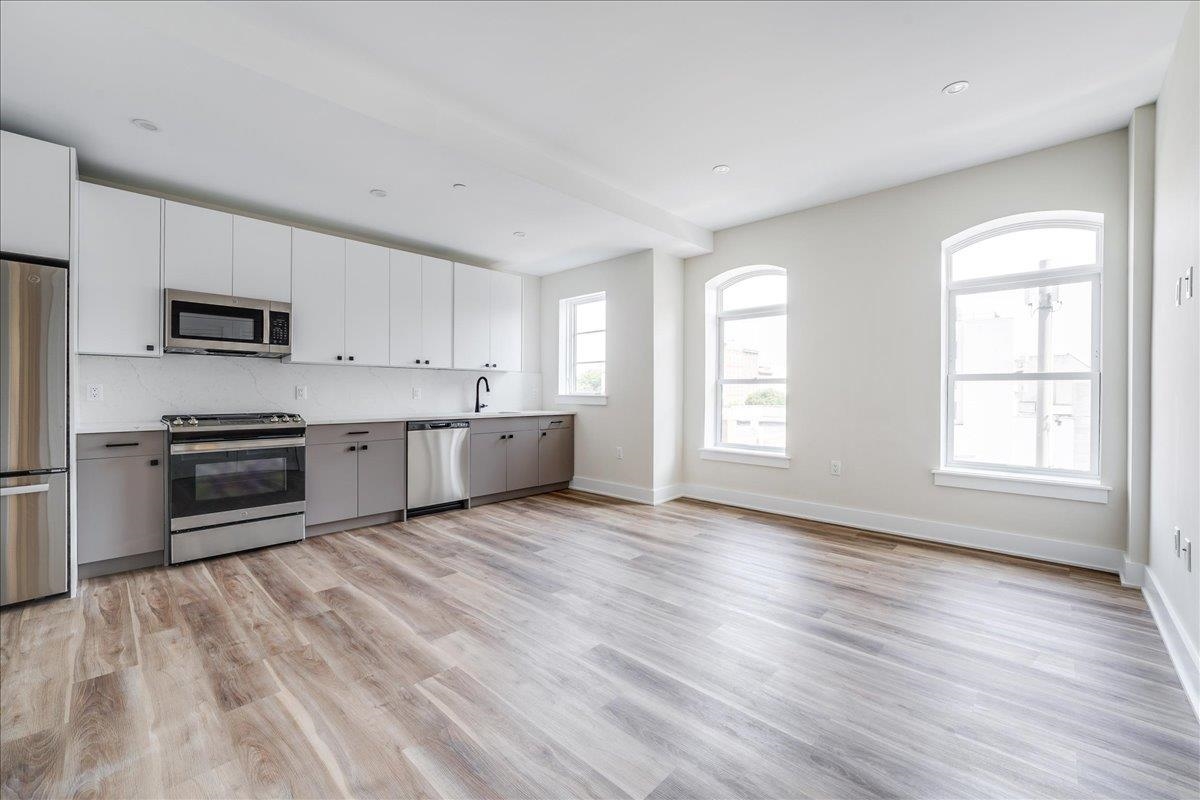 a kitchen with stainless steel appliances granite countertop a refrigerator sink and stove