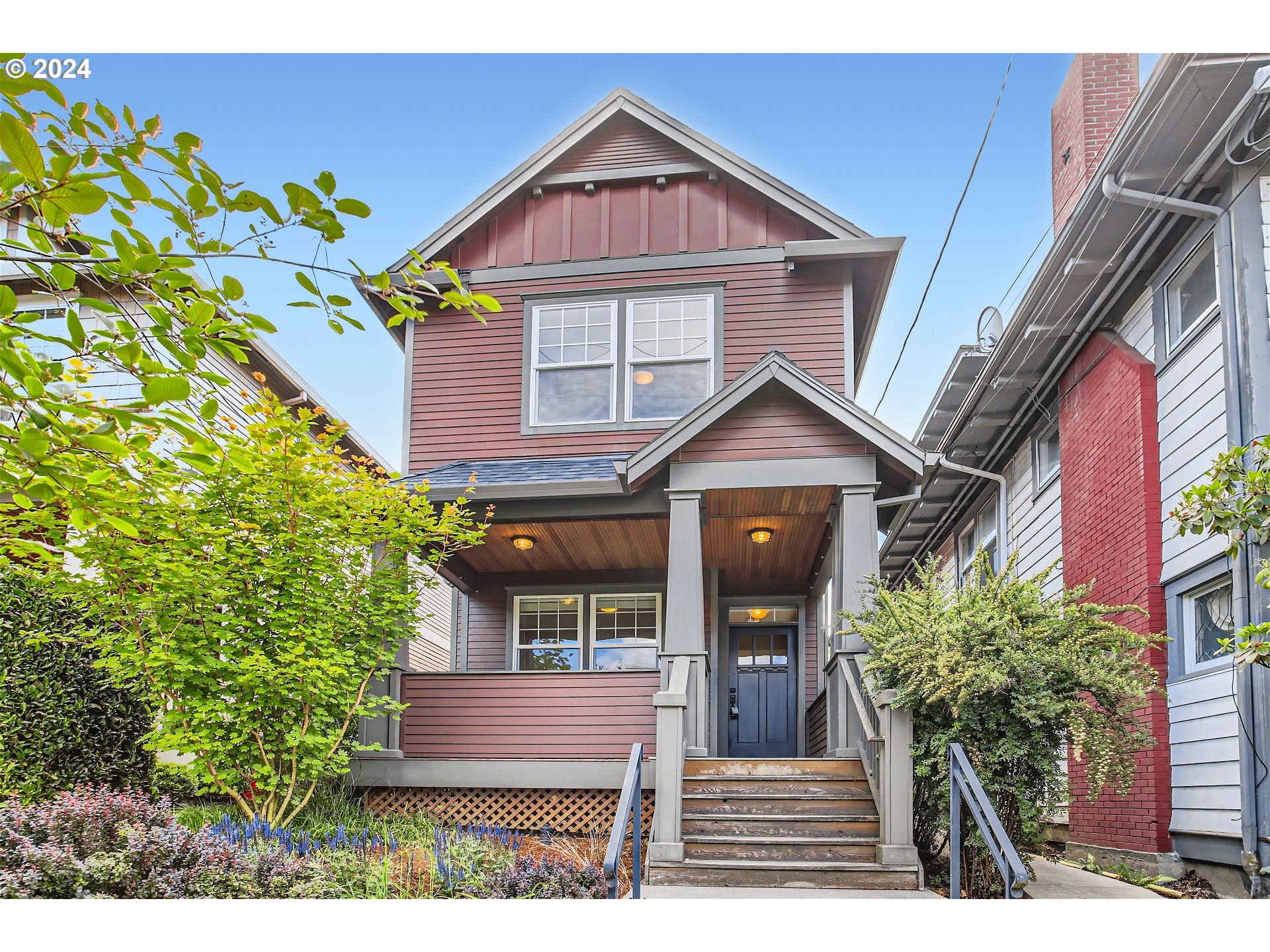 a front view of a house with a yard and potted plants