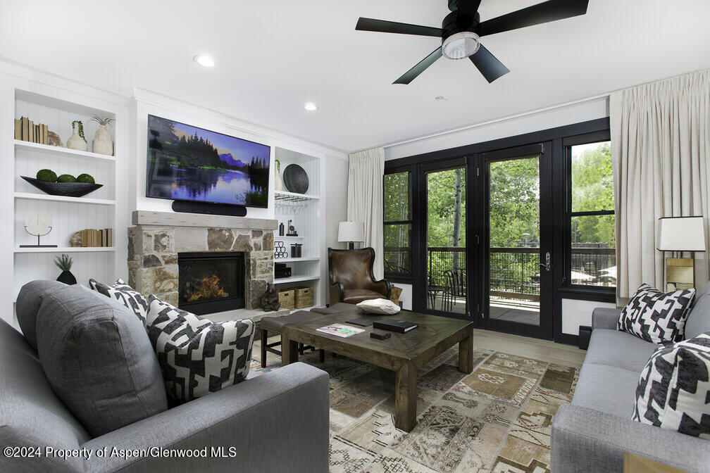 a living room with furniture a flat screen tv and a fireplace